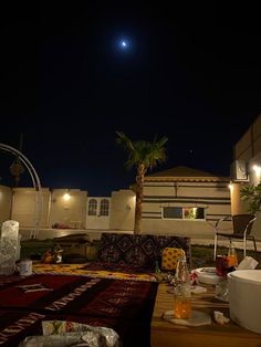 an outdoor living area with couches, table and potted plant in the foreground