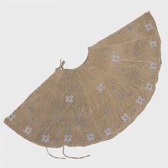 an old fan with white flowers on it is sitting in the middle of a gray background