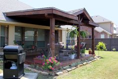 a patio covered in plants and flowers next to a grill