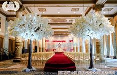 an aisle decorated with white flowers and trees for a wedding or reception at the grand ballroom