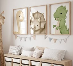 three framed pictures hang on the wall above a bench in a child's room