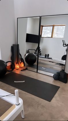 a room with mirrors, yoga mats and exercise balls on the floor in front of it