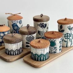 an assortment of ceramic containers on wooden trays