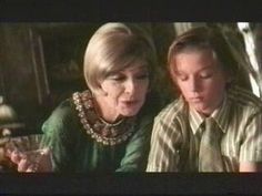 an older woman and young boy looking at something in front of them on the television screen