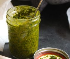 a jar filled with pesto sauce next to a small bowl