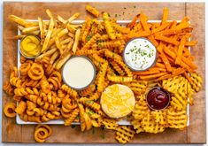 a platter filled with fries and dips next to dipping sauce