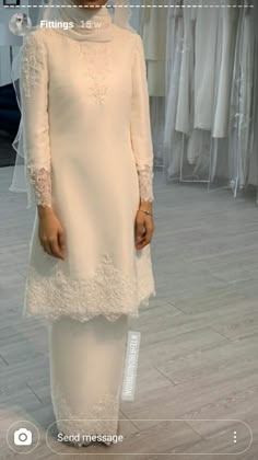 a woman standing in front of a white dress