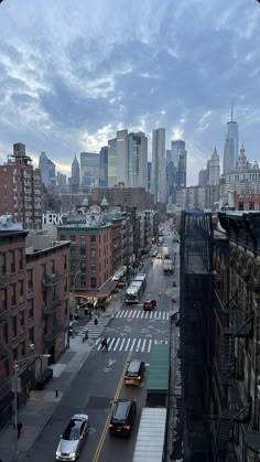 a city street filled with lots of traffic under a cloudy sky in the middle of the day