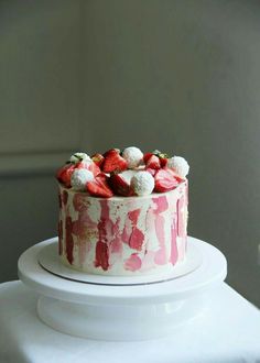 a white cake with strawberries and cream on top