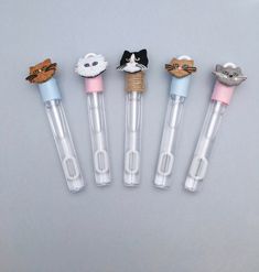 five pens with different animals in them on a white surface and one pen has an eraser