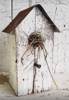 a bird's nest on top of a white wooden house