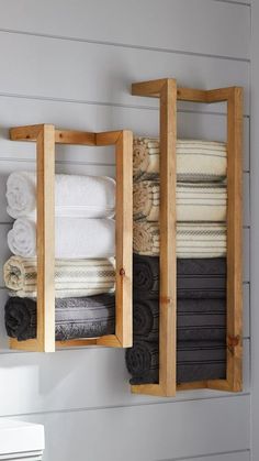 towels are stacked in wooden boxes on the wall