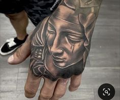 a person with a tattoo on their hand holding onto the palm of his hand,