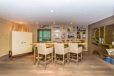 a dining room table and chairs with pictures on the wall behind it in an apartment