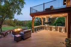 an outdoor deck with seating and fire pit in the middle of it, overlooking a golf course