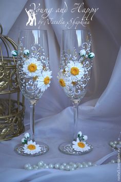 two wine glasses decorated with daisies and pearls