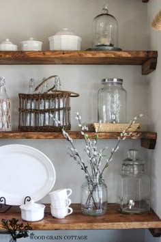 the shelves are filled with glass jars, dishes and vases on top of them