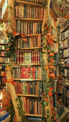 a bookshelf filled with lots of books next to a wall covered in flowers