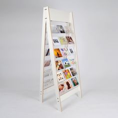 a white wooden sign with pictures on it's sides and an upside down stand