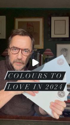 a man holding up a piece of paper with the words colours to love in 2021