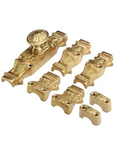 gold plated metal door handles and knobs with ornate designs on the front, set of four