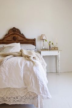 a bed with white linens and lace on it is shown in an instagramted photo