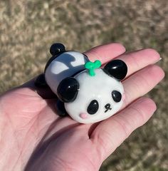 a small panda bear sitting on top of a person's hand