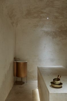 an empty room with a table and two stools in the corner next to it