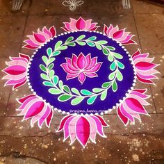 a blue and pink circular design on the ground with flowers painted on it's sides