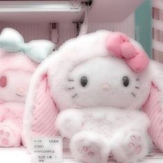 two hello kitty stuffed animals sitting next to each other