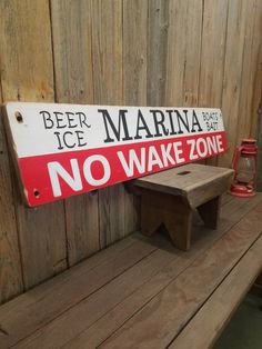 there is a sign that says beer ice marina no wake zone on the bench next to it