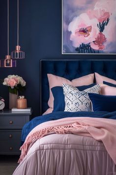 a bedroom with blue walls, pink and white bedding and artwork on the wall