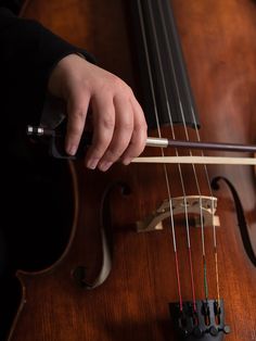 a close up of a person playing an instrument on a wooden surface with strings attached to it