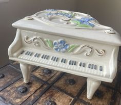 a ceramic piano sitting on top of a tile floor in front of a wall and window