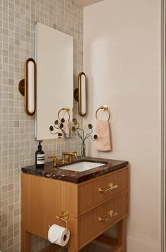 a bathroom vanity with two mirrors and a sink in front of a wall mounted mirror