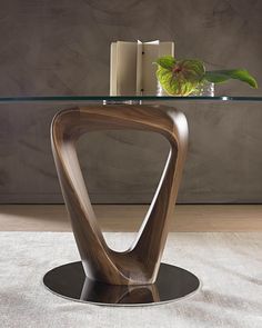 a glass table with a wooden design on top and a candle next to it in front of a wall