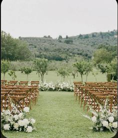 an outdoor ceremony setup with wooden chairs and flowers