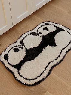 a black and white panda bear rug on the floor