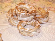 several donuts stacked on top of each other on a white plate with floral designs