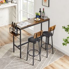 a table with two stools in front of it and a wine bottle on the counter