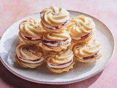 a white plate topped with cookies covered in frosting on top of a pink table