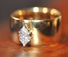 two gold wedding rings sitting on top of a wooden table