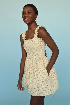 a woman in a yellow dress smiling at the camera