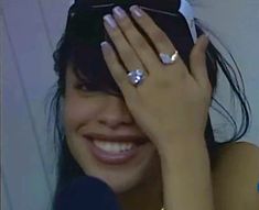 a woman holding her hands up to her face with two rings on top of her head