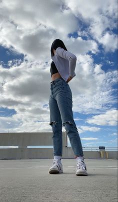 a woman is standing in the middle of an empty parking lot with her hands on her hips