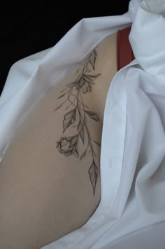 the back of a woman's stomach covered in white sheets with leaves on it