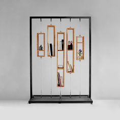 a book shelf with several books on it and hanging from the wall, in front of a gray background