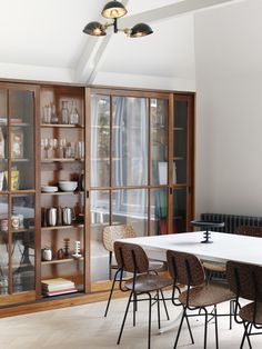 a dining room table with chairs and bookshelves