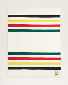 a multicolored striped towel on a white surface with a brown tag in the middle