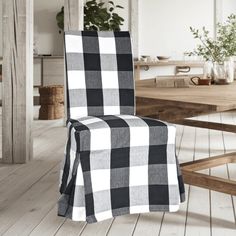 a black and white checkered chair sitting on top of a wooden floor next to a table